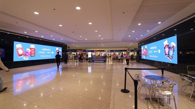 two led screens inside a mall facing each other